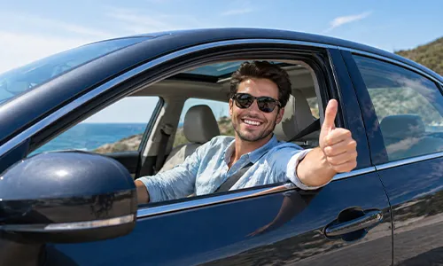 Driver smiling giving thumbsup inside vehicle roadside portrait outdoors confidently